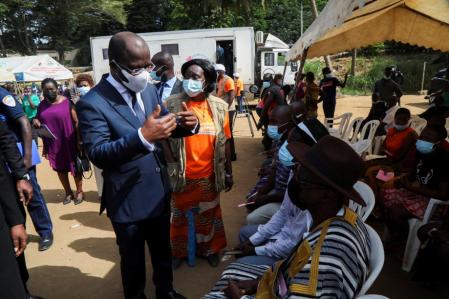 El ministro de Sanidad de Costa de Marfil,  Pierre Dimba, habla con un jefe de tribu en un centro móvil de vacunación contra la covid