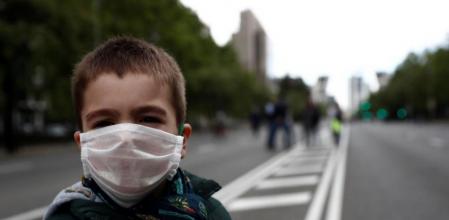 Un niño posa con la mascarilla en el Paseo de la Castellana