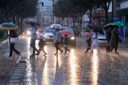 Personas cruzando por un paso de cebra en un día de lluvia&nbsp;