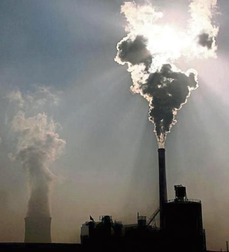 FILE PHOTO: A coal-burning power plant can be seen behind a factory in the city of Baotou, in China's Inner Mongolia Autonomous Region, October 31, 2010. REUTERS/David Gray//File Photo
