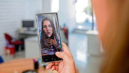 Una persona mira en su móvil el vídeo de una joven en la red musical Tik Tok, en Madrid (España), a 22 de septiembre de 2020. TikTok ha publicado este martes su tercer Informe de Transparencia, que recoge la actividad del primer semestre de 2020, en el que se eliminaron más de cien millones de vídeos por infringir las normas de la plataforma. 22 SEPTIEMBRE 2020;TECNOLOGIA;REDES SOCIALES;VÍDEOS;MÚSICA Europa Press / Europa Press 22/09/2020