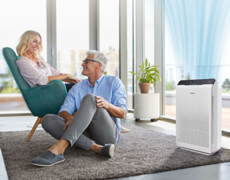 Una pareja en el salón con un purificador Winix