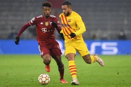 Barcelona's Dutch forward Memphis Depay (R) and Bayern Munich's French forward Kingsley Coman vie for the ball during the UEFA Champions League group E football match FC Bayern Munich v FC Barcelona in Munich, southern Germany on December 8, 2021. (Photo by Christof STACHE / AFP)