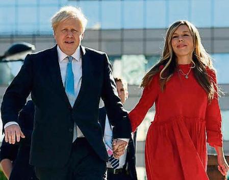 (FILES) In this file photo taken on October 6, 2021 Britain's Prime Minister Boris Johnson (L) and his wife Carrie (R) arrive at the Manchester Central convention centre ahead of his keynote speech on the final day of the annual Conservative Party Conference in Manchester, northwest England. - Johnson became a father again, after his wife, Carrie, gave birth to a girl, Downing Street said on December 9, 2021. (Photo by Ben STANSALL / AFP)