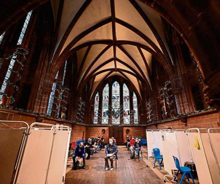 People wait in the observation after receiving a dose of the Covid-19 vaccine at a vaccination clinic set up at Chester Cathedral on December 16, 2021 as the UK steps up the country's booster drive to fight a 