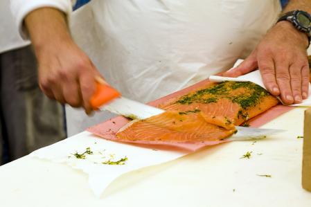 Persona cortando salmón ahumado