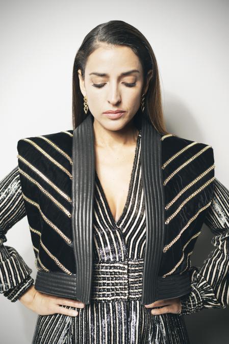 Vestido	batín	de	gasa	nude	con	listado	fil	coupé
negro	y	chaleco	de	terciopelo	negro,	piel	y	
cadenas	metálicas,	de	Teresa	Helbig.	
Pendientes	de la colección LV Volt, de Louis
Vuitton.