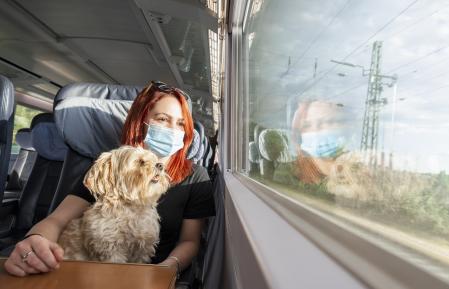 Una joven viaja con su perro en tren durante la pandemia