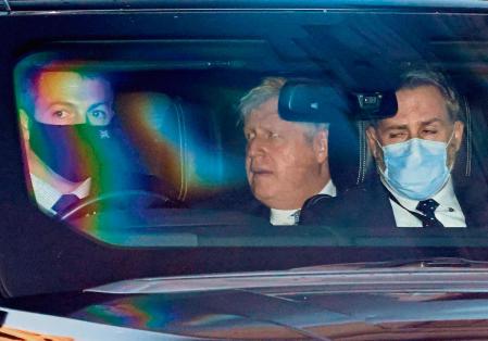 Britain's Prime Minister Boris Johnson (C) is driven away from the House of Commons, after attending Prime Minister Questions (PMQs), in central London on January 12, 2022. - UK Prime Minister Boris Johnson Wednesday apologised for attending a lockdown-breaching party held in his Downing Street garden, but deflected calls to resign as the opposition leader called him a 