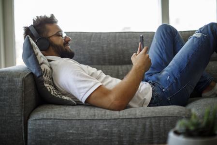 Joven escuchando un audiolibro desde su móvil