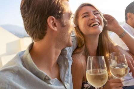 Una pareja bebe vino blanco