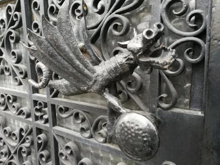 Detalle de la maneta de una puerta de una cerrajería que tiene forma de dragón.