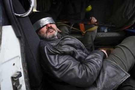 Las tropas ucranianas escoltan a un hombre que sospechan que es un agente ruso en Kíev, Ucrania.