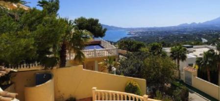 Villas lujosas y urbanizaciones de adosados salpican el paisaje de la sierra sobre la bahía.