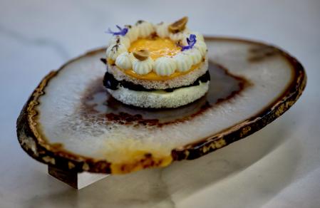 La tartaleta de yema, idiazábal y trufa que sirven sobre un espejo.