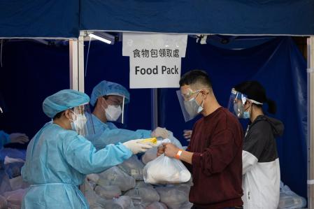 El residente de un edificio en cuarentena recoge una bolsa con comida