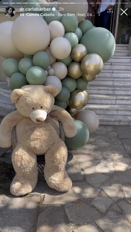 Un oso gigante junto a unos globos