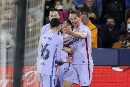 Barcelona's Luuk de Jong, right, celebrates after scoring his side's third goal during a Spanish La Liga soccer match between Levante and Barcelona at the Ciutat de Valencia stadium in Valencia, Spain, Sunday, April 10, 2022. (AP Photo/Alberto Saiz)