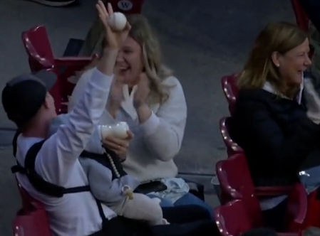 El hombre atrapa la pelota con una mano mientras con la otra le da el biberón al pequeño
