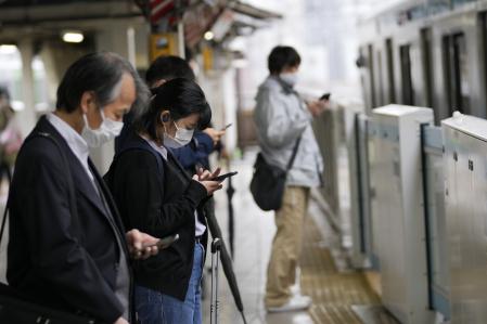 Personas con mascarilla esperan el tren en una estación en Tokio