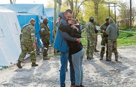 Azovstal steel plant employee Maxim, last name withheld, evacuated from Mariupol, hugs his son Matvey, who had earlier left the city with his relatives, as they meet at a temporary accommodation centre during Ukraine-Russia conflict in the village of Bezimenne in the Donetsk Region, Ukraine May 1, 2022. REUTERS/Alexander Ermochenko