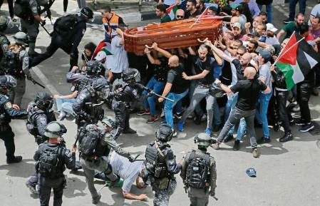 Israeli police confront with mourners as they carry the casket of slain Al Jazeera veteran journalist Shireen Abu Akleh during her funeral in east Jerusalem, Friday, May 13, 2022. Abu Akleh, a Palestinian-American reporter who covered the Mideast conflict for more than 25 years, was shot dead Wednesday during an Israeli military raid in the West Bank town of Jenin. (AP Photo/Maya Levin)