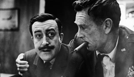 American actor Sterling Hayden (1916-1986), as General Jack Ripper, holds a cigar in his mouth and puts his arm around English born actor Peter Sellers (1925-1980), as Group Captain Lt. Mandrake, in a still from the Stanley Kubrick (1928-1999) directed film, 
