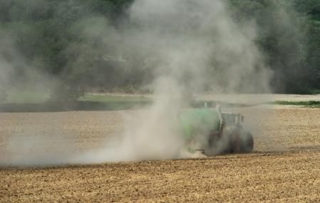 Casi no vemos el tractor por el polvo que se levanta en el campo.
