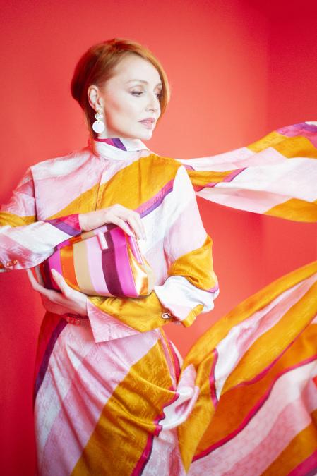 La actriz luce un total look de Fendi compuesto por camisa fluida y pantalón con falda superpuesta, pendientes dobles y bolso Fendi First de piel y ante