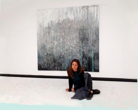 La artista Marta Juvanteny reflexionando enfrente de una de sus obras.