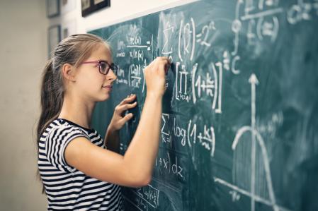 Teenage girl solving mathematical problems. The boy is drawing a graph of a mathematical function.
Nikon D850