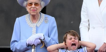 El príncipe Luis de Cambridge se tapa los oídos durante la exhibición aérea, junto a su bisabuela, la reina Isabel II (DANIEL LEAL / AFP)