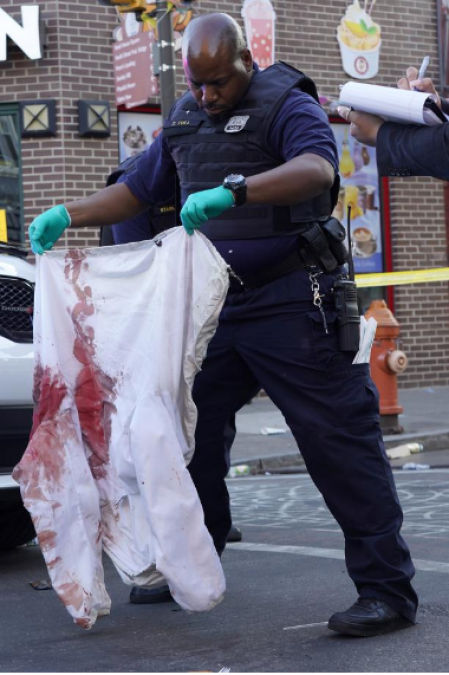 Un policía de Filadelfia sostiene una chaqueta manchada de sangre