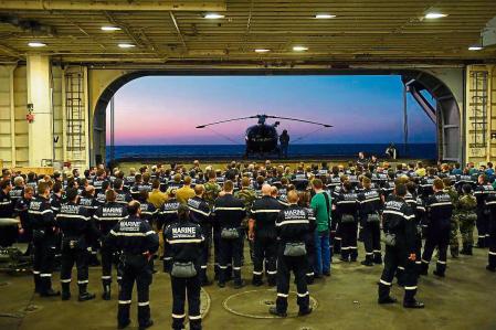 French navy soldiers wait for the arrival of French Army Chief of Staff General Pierre de Villiers, aboard the French Charles-de-Gaulle aircraft carrier, on November 23, 2015 at the eastern Mediterranean sea, as part of operation Chammal in Syria and Irak against the Islamic State group. France launched air strikes against Islamic State group targets in Iraq on November 23 in the first sorties from the Charles de Gaulle aircraft carrier, newly deployed in the eastern Mediterranean. AFP PHOTO / ANNE-CHRISTINE POUJOULAT