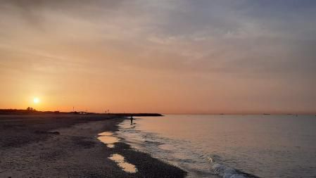 Sale el sol entre el polvo sahariano en la playa de Gavà.