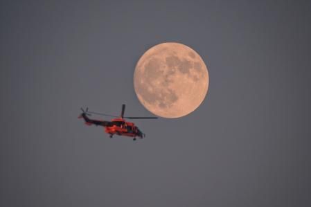 Un helicóptero con la luna casi llena.