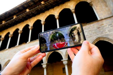 El ou com balla luciendo en el claustro del monasterio de Pedralbes visto a través del móvil.