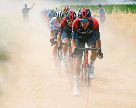 UAE Team Emirates team's Slovenian rider Tadej Pogacar (3rd R) wearing the best young rider's white jersey, Ineos Grenadiers team's British rider Geraint Thomas (2nd R) and Ineos Grenadiers team's Dutch rider Dylan Van Baarle (R) cycle across a cobblestone sector in the final kilometers of the 5th stage of the 109th edition of the Tour de France cycling race, 153,7 km between Lille and Arenberg Porte du Hainaut, in northern France, on July 6, 2022. (Photo by Bernard PAPON / POOL / AFP)