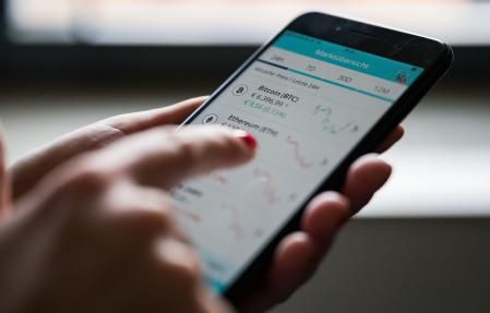 Una mujer operando con criptomonedas desde una aplicación móvil