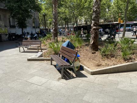 Las pertenencias de una persona sin hogar en un banco cerca de la Diagonal