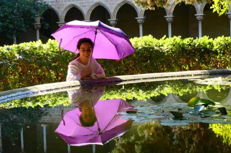 Cristina Alís, con reflejos del paraguas en el estanque de la fuente del claustro de Pedralbes-