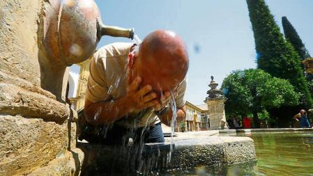 CÓRDOBA, 16/07/2022.- Un turista se refresca en una fuente del Patio de los Naranjos de la Mezquita-Catedral de Córdoba este sábado. La Agencia Estatal de Meteorología (Aemet) pone este sábado en alerta roja a cinco comunidades -Aragón, Cantabria, Extremadura, Navarra y La Rioja- en vista de las altas temperaturas, que podrán llegar a los 44 ºC durante la tarde, y sitúa a otras siete en aviso naranja. EFE/Salas