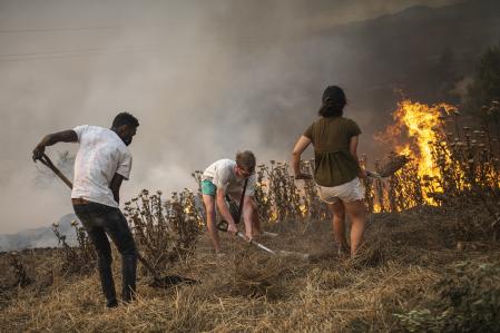 Vecinos de Sant Fruitós del Bages luchan contra las llamas en los primeros momentos del incendio, ayer