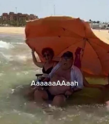 La familia instaló a los abuelos en el agua con sus sombrillas sin esperar lo que estaba por venir