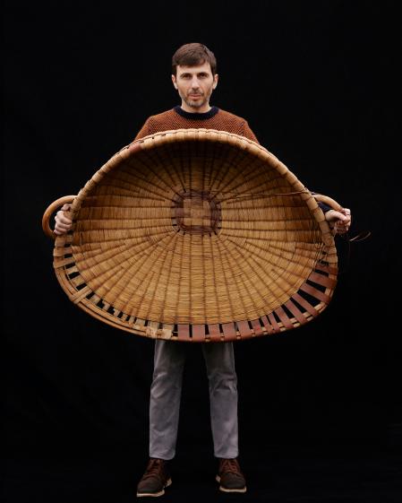 Santiago Basteiro sostiene una de sus cestas reparadas artesanalmente