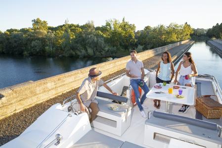 Unas personas pasando por el Canal du Midi en barco