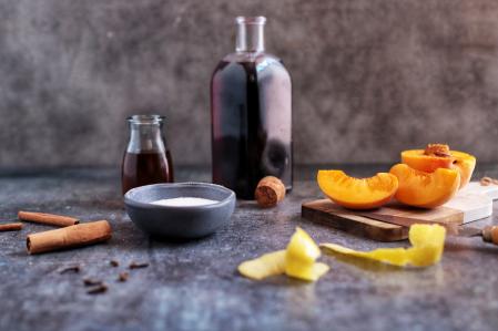 Canela, naranja, limón, azúcar y vino para macerar los melocotones