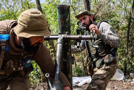 TOPSHOT - Ukrainian volunteer fighters prepare a mortar launcher at a position along the front line in the Donetsk region on August 22, 2022, amid the Russian invasion of Ukraine. (Photo by ANATOLII STEPANOV / AFP)