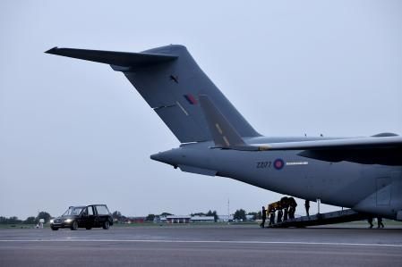 Miembros de la unidad Queen's Color Squadron transportan el féretro de Isabel II desde el avión hasta el coche fúnebre, ya en Londres
