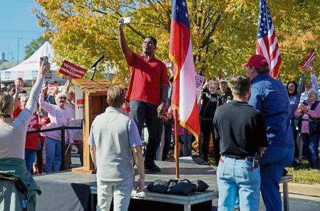 U.S. Senate candidate and former football player Herschel Walker takes a selfie while on stage at a campaign rally at the University of Georgia in Columbus, Georgia, U.S., October 21, 2022. REUTERS/Cheney Orr